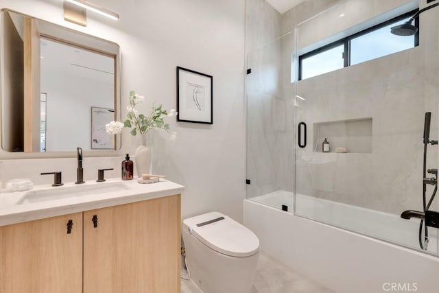 full bath with toilet, vanity, and bath / shower combo with glass door