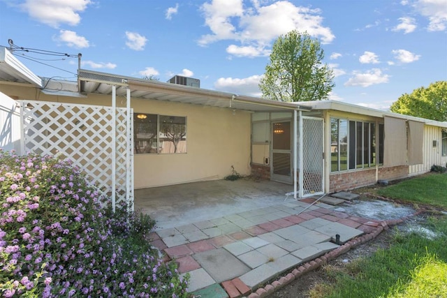 back of property with stucco siding and cooling unit