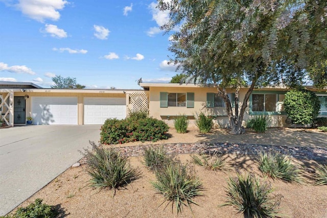 ranch-style house featuring an attached garage, driveway, and stucco siding