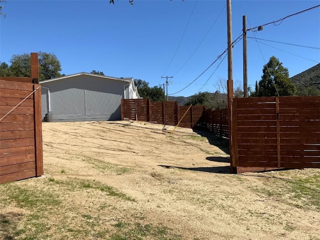 view of yard featuring an outdoor structure and fence