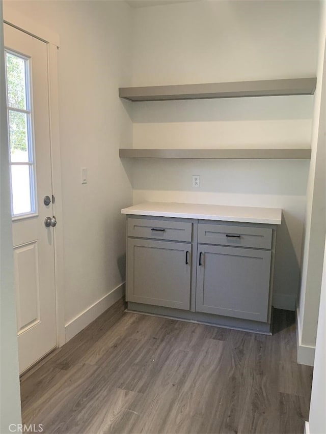 washroom featuring baseboards and dark wood-style floors