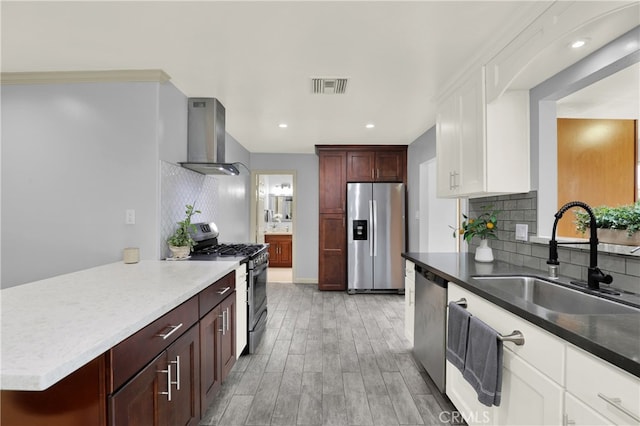 8731 Bel Air St, Buena Park, CA 90620 - kitchen with appliances with stainless steel finishes, wall chimney range hood, a sink, decorative backsplash, and light wood-style flooring