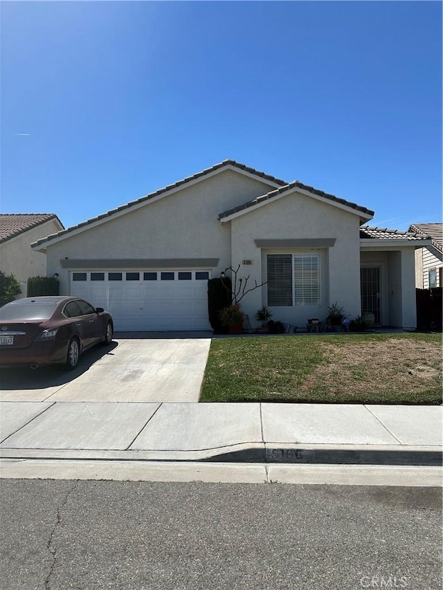 ranch-style house with a garage, a front lawn, stucco siding, a tiled roof, and concrete driveway