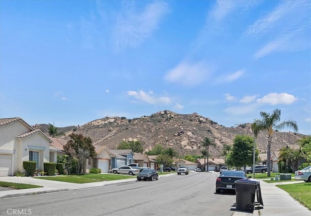 5166 Contay Way, Jurupa Valley, CA 92509 - view of asphalt road featuring a residential view, sidewalks, a mountain view, and curbs