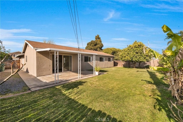 back of property featuring a yard, a patio, stucco siding, and a fenced backyard