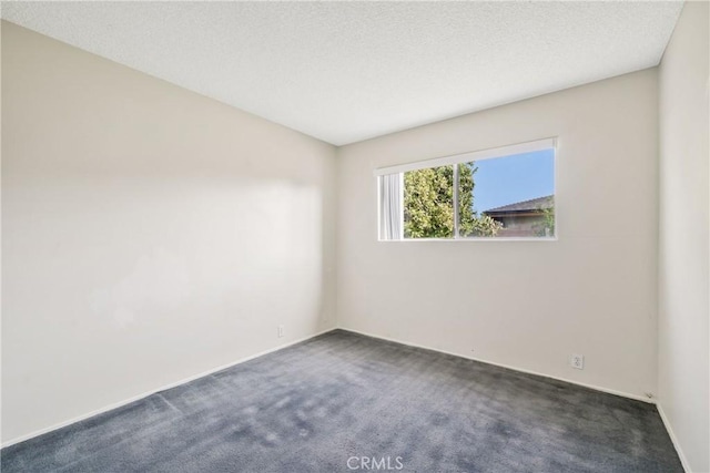 empty room featuring dark carpet and baseboards