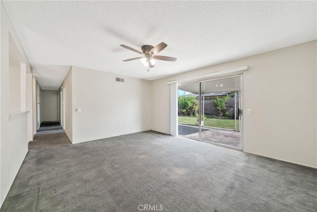 empty room featuring visible vents, a ceiling fan, carpet, and a textured ceiling