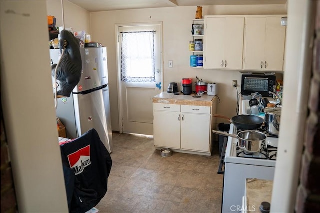9925 Woodrich Ln, El Monte, CA 91731 - kitchen featuring stove, white cabinetry, freestanding refrigerator, and open shelves