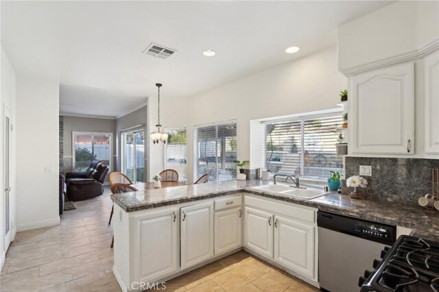 kitchen with a peninsula, stainless steel dishwasher, a sink, visible vents, and a notable chandelier