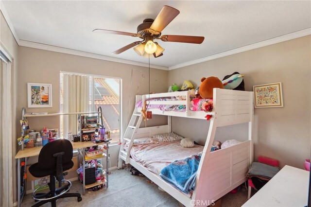 carpeted bedroom featuring ceiling fan and ornamental molding