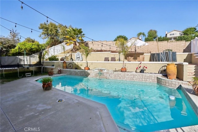 view of swimming pool featuring a fenced backyard, a fenced in pool, and a trampoline