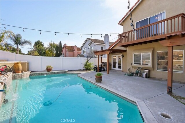 view of swimming pool with a patio area, a fenced backyard, a fenced in pool, and french doors