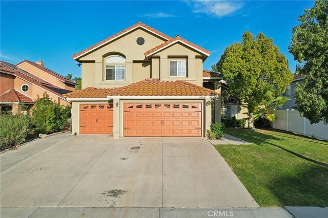 view of front of property with a tile roof, concrete driveway, fence, a front yard, and stucco siding