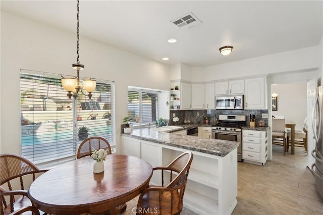 40540 Windsor Rd, Temecula, CA 92591 - kitchen featuring stainless steel appliances, open shelves, a peninsula, white cabinetry, and tasteful backsplash