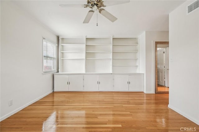 spare room with a ceiling fan, baseboards, visible vents, and light wood-style floors