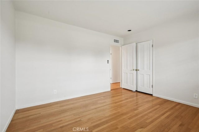 unfurnished room featuring light wood-style floors, baseboards, and visible vents