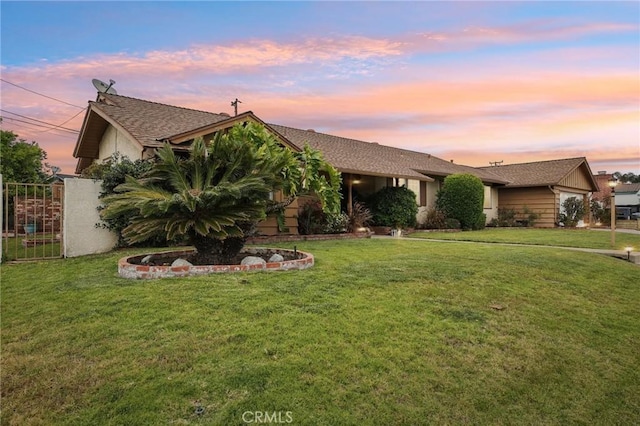 single story home with stucco siding, fence, and a yard