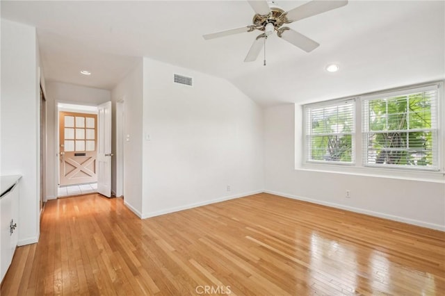 spare room featuring light wood-style floors, a healthy amount of sunlight, baseboards, and visible vents
