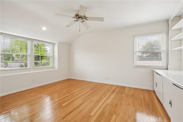 empty room featuring light wood finished floors, a ceiling fan, baseboards, recessed lighting, and vaulted ceiling