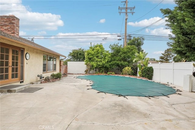 view of pool featuring french doors, a fenced in pool, a patio, and a fenced backyard