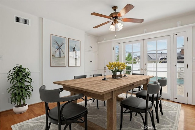 dining room with ceiling fan, visible vents, french doors, and light wood finished floors