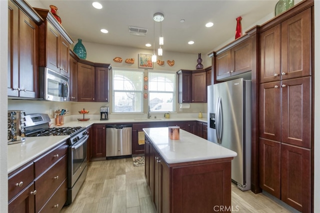 kitchen featuring visible vents, a center island, a sink, appliances with stainless steel finishes, and recessed lighting
