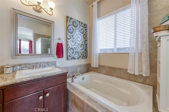 bathroom with a bath, a stall shower, vanity, and a wealth of natural light