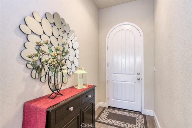 doorway to outside featuring wood finished floors and baseboards