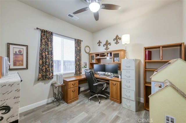 office featuring light wood finished floors, baseboards, a ceiling fan, and visible vents