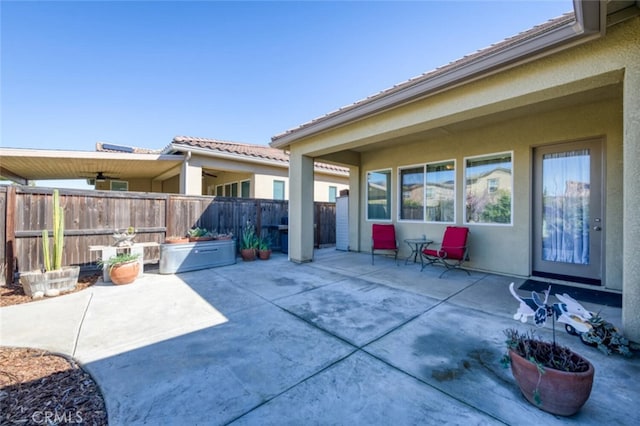 view of patio / terrace with ceiling fan and fence
