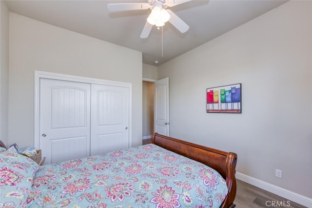 bedroom with wood finished floors, ceiling fan, baseboards, and a closet