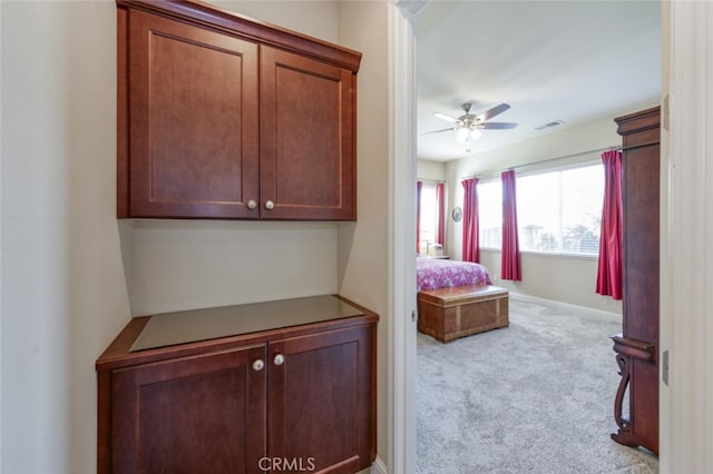 corridor featuring carpet flooring, baseboards, and visible vents