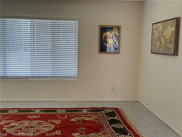 unfurnished room featuring baseboards and tile patterned flooring