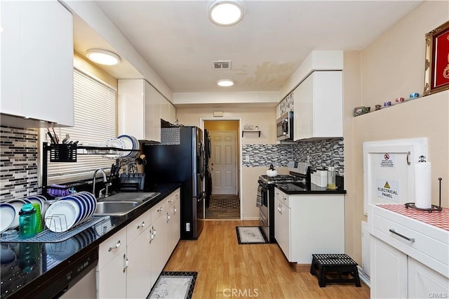 kitchen with stainless steel appliances, visible vents, white cabinetry, and a sink
