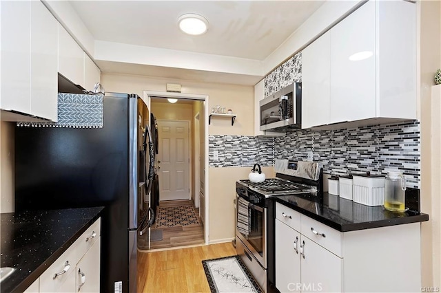 kitchen featuring stainless steel appliances, white cabinets, light wood-type flooring, and backsplash