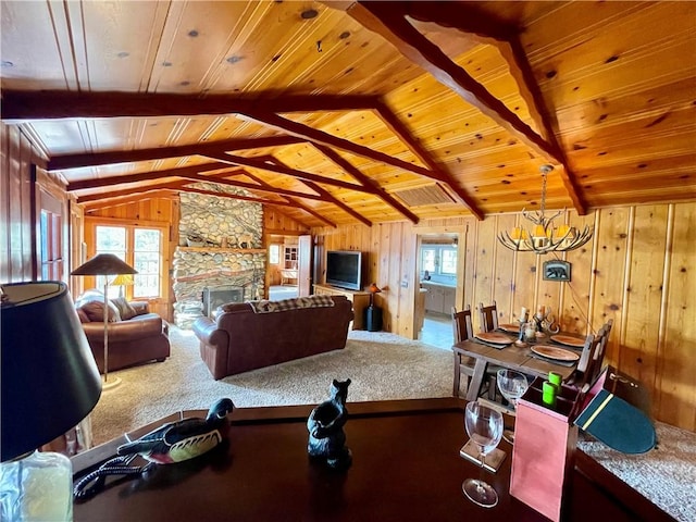 39121 Lake Dr, Bass Lake, CA 93604 - carpeted dining space featuring wood ceiling, wood walls, a stone fireplace, and a chandelier