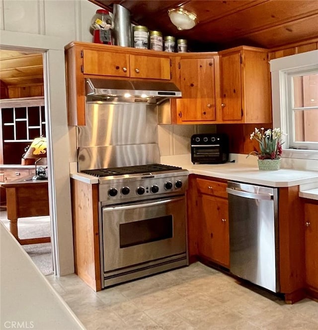 39121 Lake Dr, Bass Lake, CA 93604 - kitchen with appliances with stainless steel finishes, under cabinet range hood, brown cabinetry, and light countertops