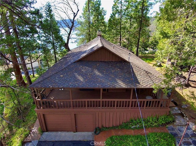 39121 Lake Dr, Bass Lake, CA 93604 - view of front facade with roof with shingles, a garage, and a chimney