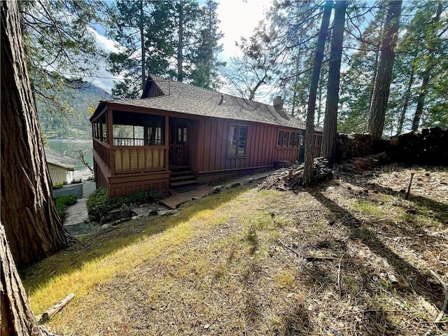 39121 Lake Dr, Bass Lake, CA 93604 - back of house with board and batten siding, roof with shingles, and a chimney