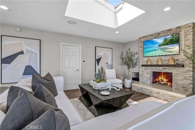 living room with a skylight, wood finished floors, a fireplace, and recessed lighting