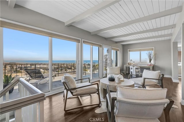 sunroom / solarium with beamed ceiling and a water view
