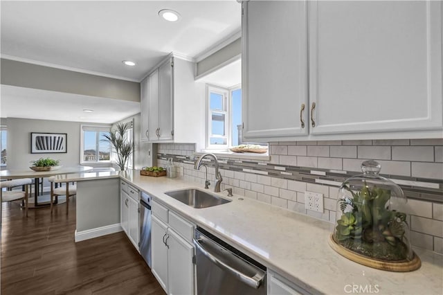 kitchen with ornamental molding, white cabinetry, dark wood finished floors, dishwasher, and a sink