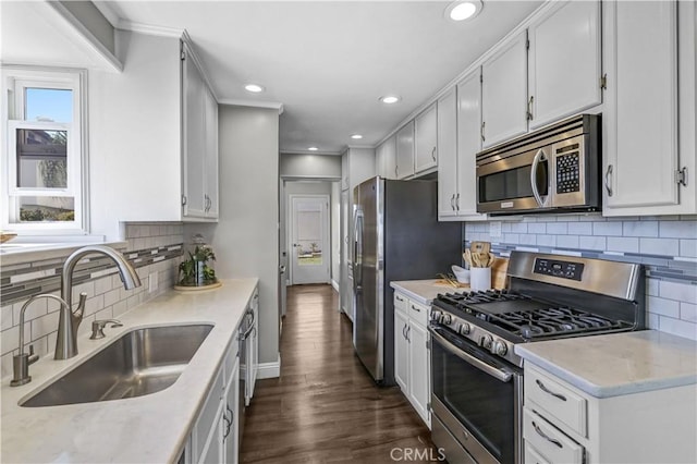 kitchen with tasteful backsplash, dark wood-style flooring, a sink, and appliances with stainless steel finishes