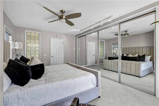 bedroom featuring track lighting, a closet, and carpet