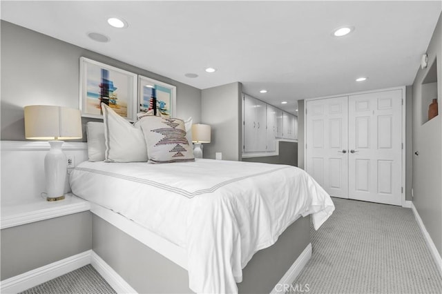 bedroom with a closet, baseboards, carpet, and recessed lighting