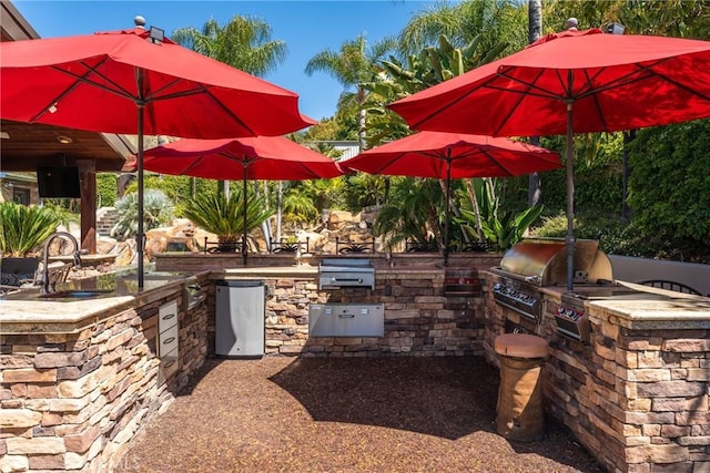 view of patio featuring an outdoor kitchen, area for grilling, and a sink