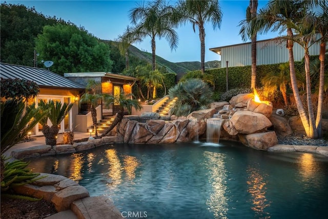 view of swimming pool featuring stairway, a mountain view, and a fenced in pool