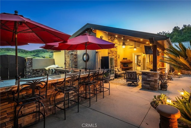 view of patio with a ceiling fan and a bar