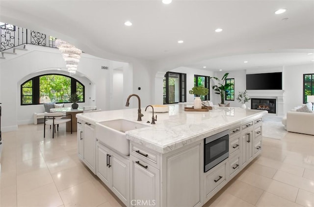 kitchen with recessed lighting, a sink, open floor plan, and stainless steel microwave