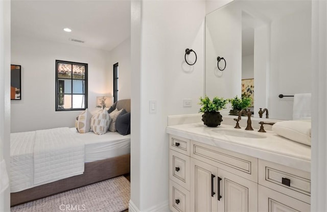 bathroom featuring visible vents, vanity, and ensuite bath